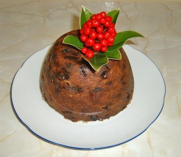 Christmas pudding on white plate decorated with skimmia