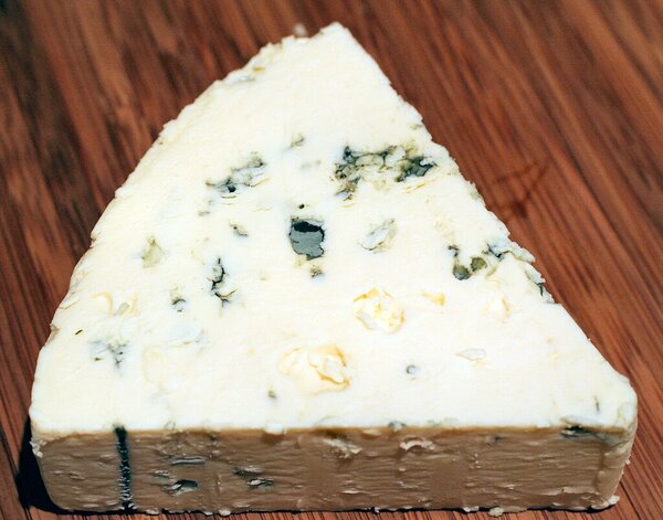 Triangular slice of Danish Blue cheese point right