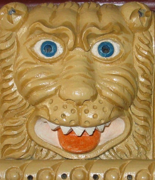 Carved and painted Tudor lion mask dark-yellow face, blue eyes.
